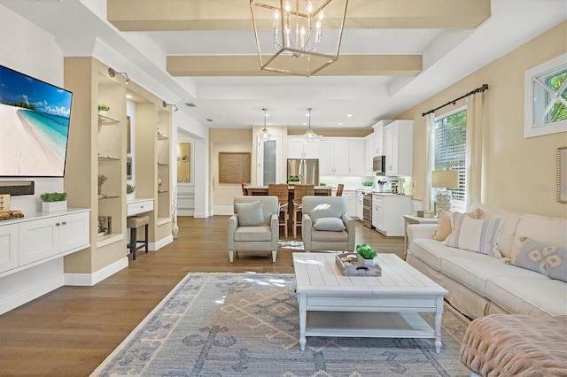 living room featuring wood-type flooring, built in features, and a notable chandelier