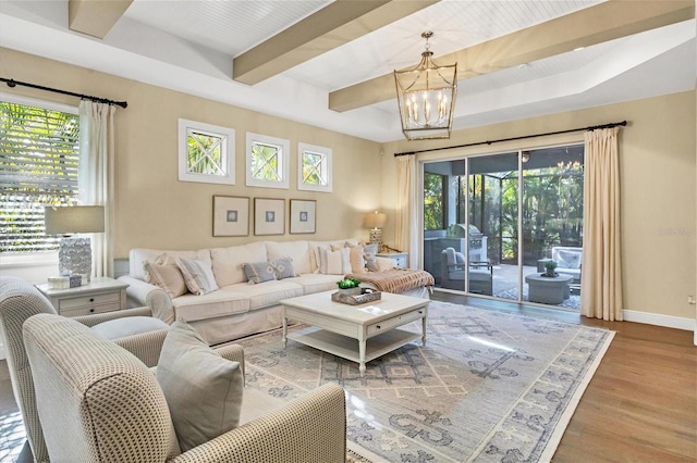 living room featuring hardwood / wood-style floors, beamed ceiling, and an inviting chandelier