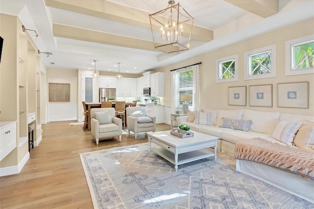 living room with a chandelier and light wood-type flooring