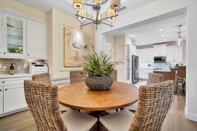 dining space featuring sink and light wood-type flooring