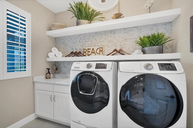 laundry area featuring washer and clothes dryer and cabinets