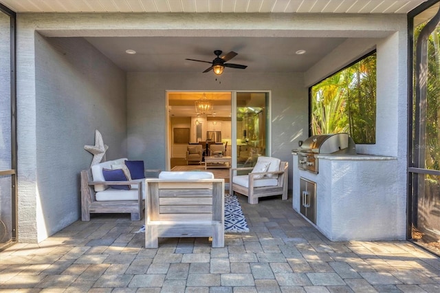 view of patio featuring a grill, ceiling fan, and an outdoor kitchen