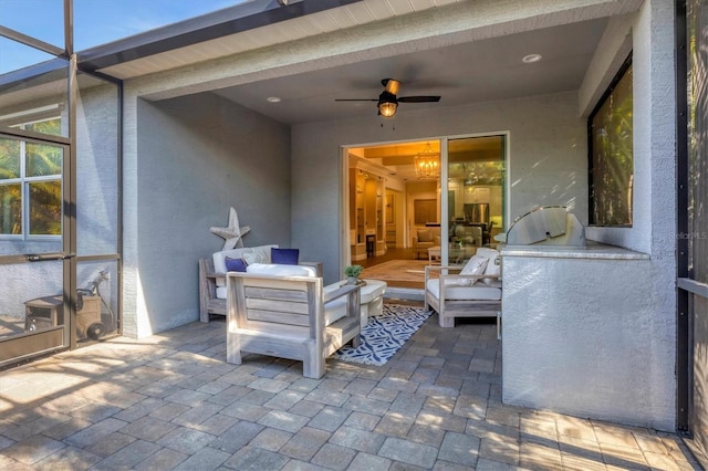 view of patio / terrace with glass enclosure, ceiling fan, and an outdoor living space