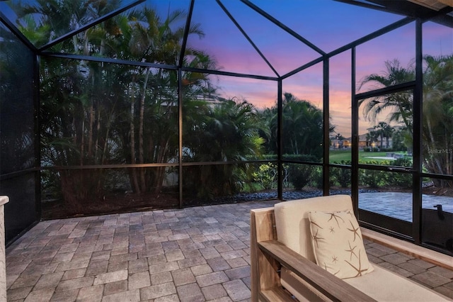 patio terrace at dusk featuring a lanai