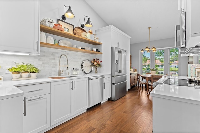 kitchen with tasteful backsplash, stainless steel appliances, decorative light fixtures, dark hardwood / wood-style flooring, and white cabinetry