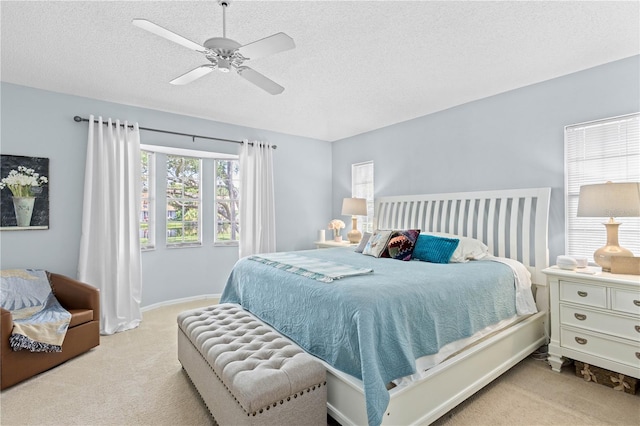 bedroom featuring light carpet, a textured ceiling, and ceiling fan