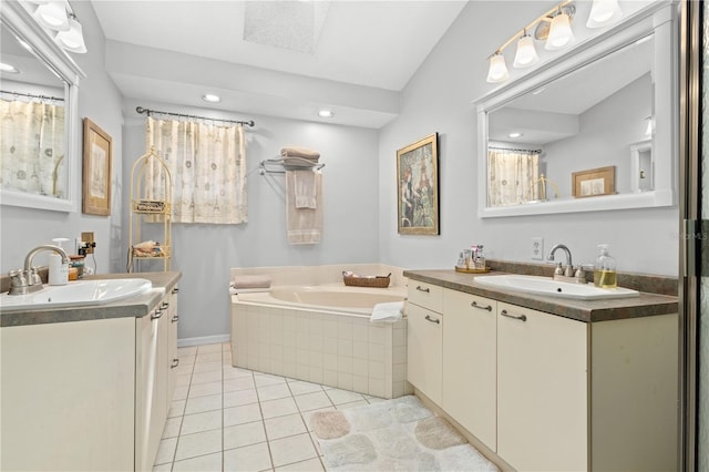 bathroom featuring vanity with extensive cabinet space, tiled tub, and double sink