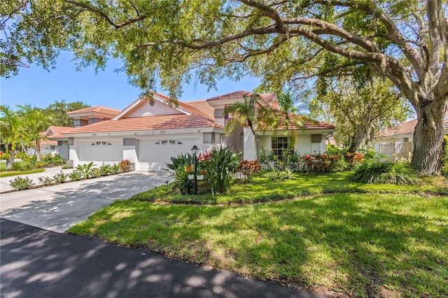 mediterranean / spanish house featuring a garage and a front yard