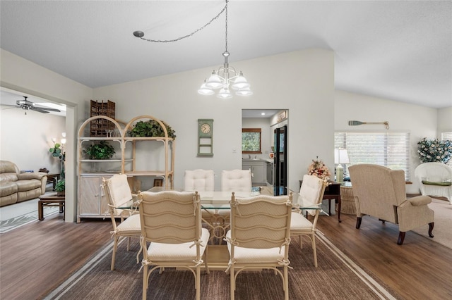 dining space with wood-type flooring, ceiling fan with notable chandelier, and vaulted ceiling