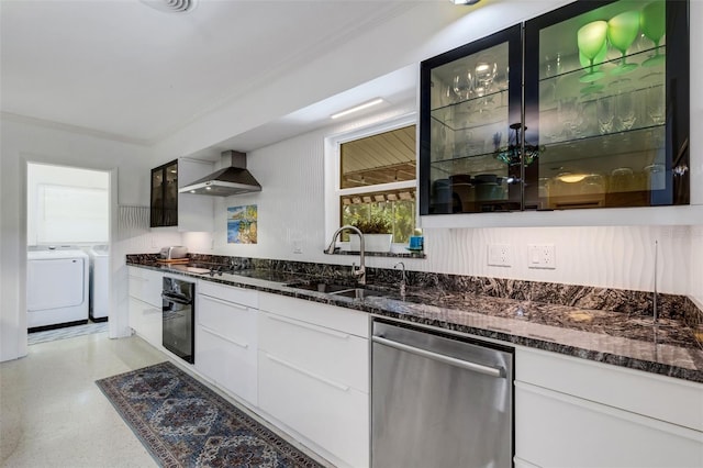 kitchen with washing machine and clothes dryer, white cabinetry, sink, wall chimney exhaust hood, and appliances with stainless steel finishes