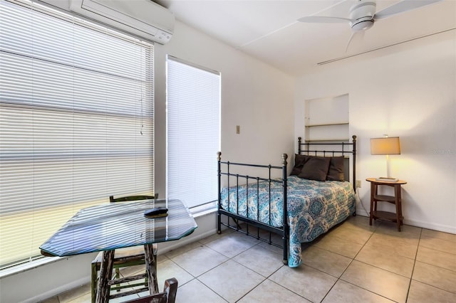 tiled bedroom with a wall unit AC and ceiling fan