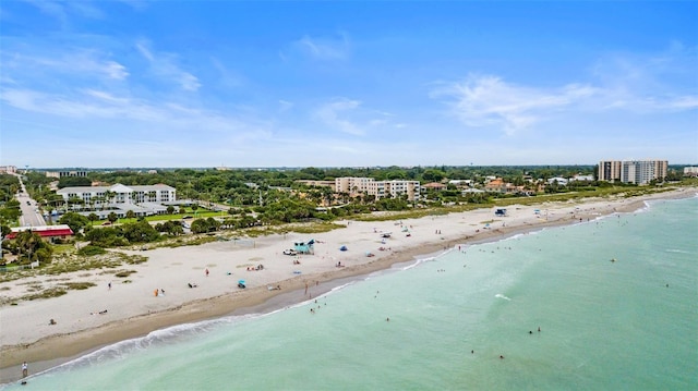 drone / aerial view featuring a beach view and a water view