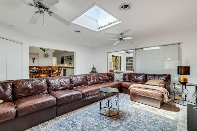 living room with a skylight and ceiling fan