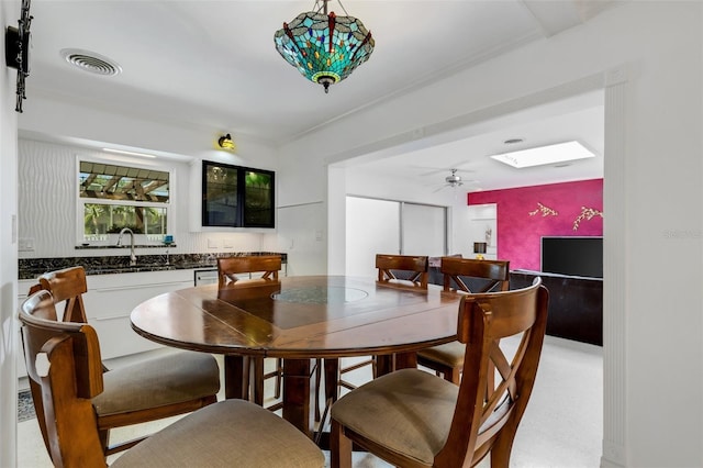 dining space with ceiling fan and sink