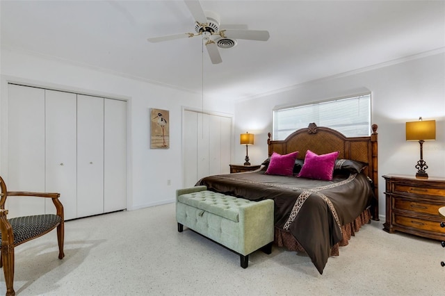 bedroom featuring ornamental molding, ceiling fan, and multiple closets