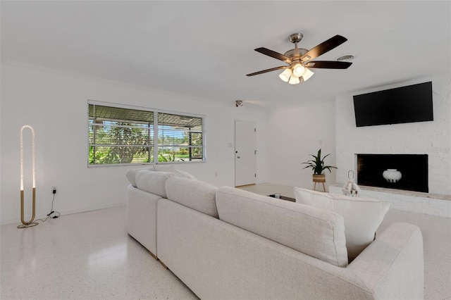 701 Armada Rd S, Venice, FL 34285 - living area featuring light speckled floor, a ceiling fan, and a fireplace