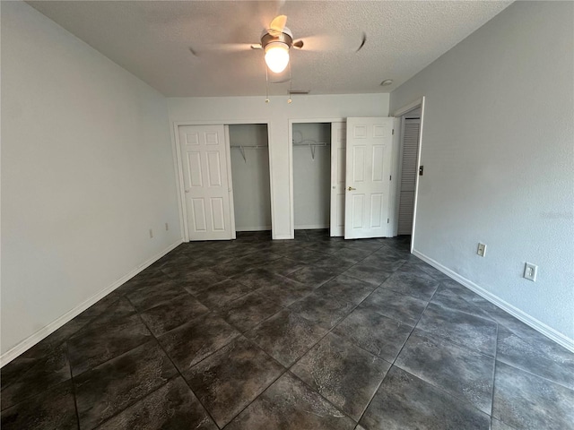 unfurnished bedroom featuring ceiling fan, a textured ceiling, and dark tile floors