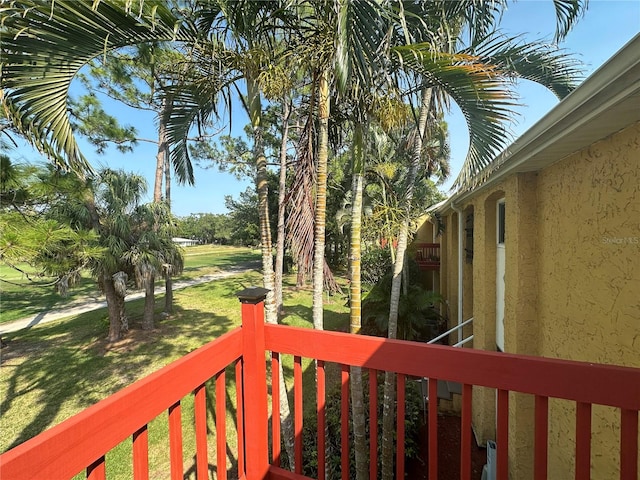 wooden deck featuring a lawn