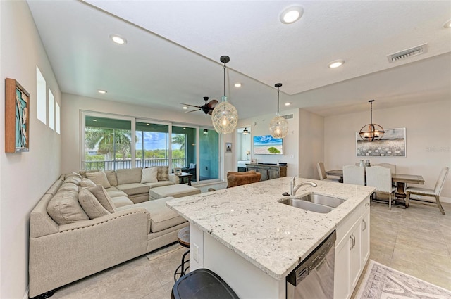 kitchen featuring light tile flooring, an island with sink, stainless steel dishwasher, white cabinets, and sink