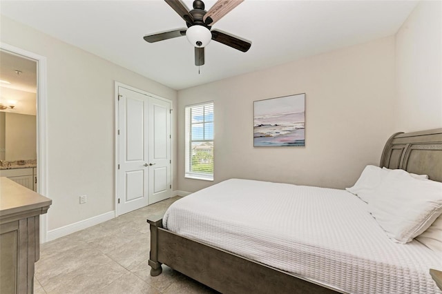 bedroom with a closet, ceiling fan, light tile floors, and ensuite bath