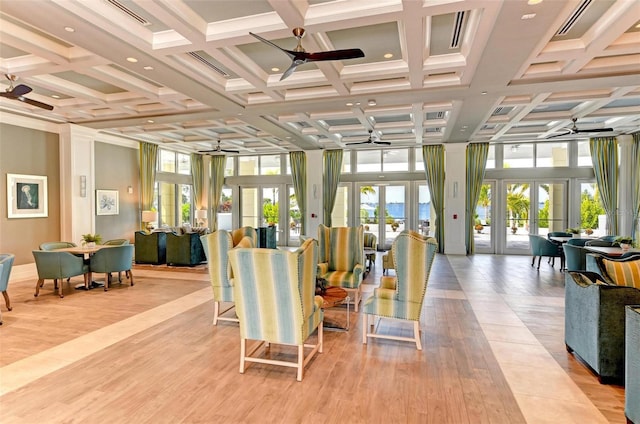 interior space with coffered ceiling, ceiling fan, french doors, and a healthy amount of sunlight