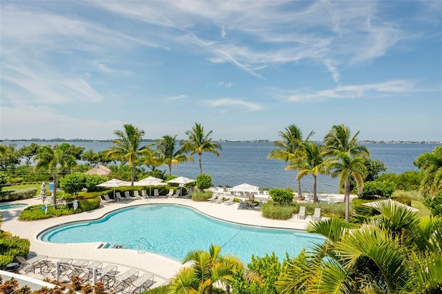 view of swimming pool featuring a water view and a patio area