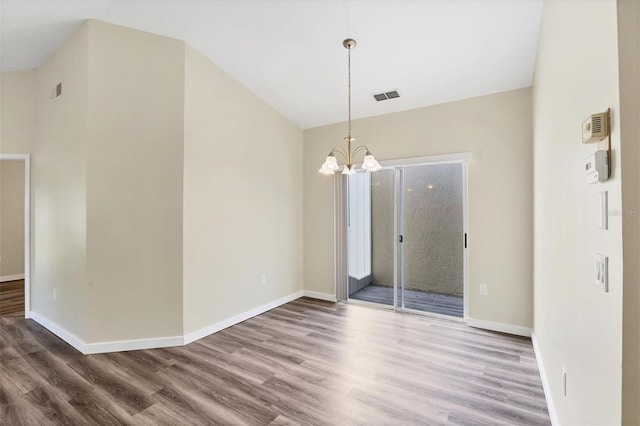 spare room featuring a chandelier and hardwood / wood-style flooring