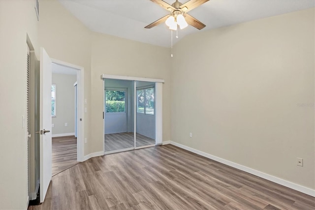 empty room featuring light wood-type flooring, ceiling fan, and lofted ceiling