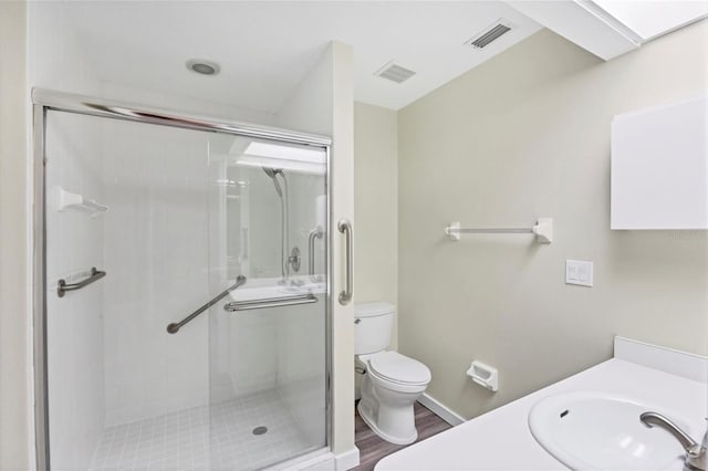 bathroom with toilet, vanity, an enclosed shower, and hardwood / wood-style flooring