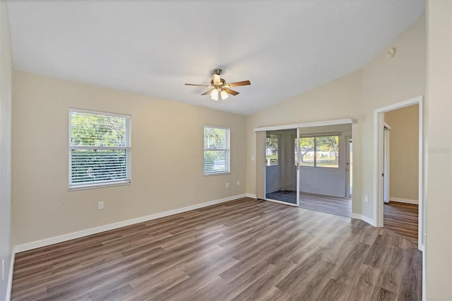 empty room with vaulted ceiling, ceiling fan, wood finished floors, and baseboards