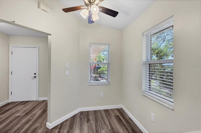 spare room with baseboards, vaulted ceiling, dark wood finished floors, and a healthy amount of sunlight