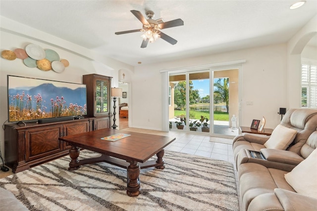 living room with ceiling fan, a healthy amount of sunlight, and light tile flooring