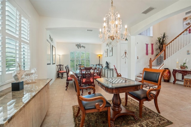 dining space with plenty of natural light, a chandelier, light tile floors, and lofted ceiling