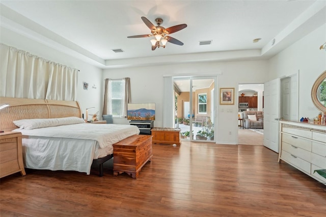 bedroom with ceiling fan, multiple windows, and hardwood / wood-style floors