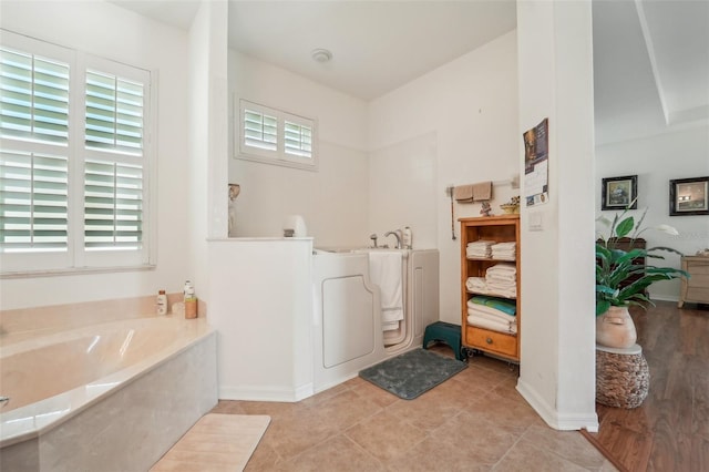 bathroom with a washtub and tile flooring