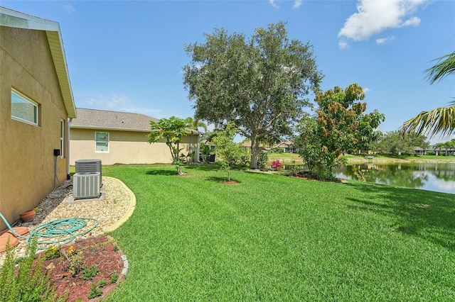 view of yard with a water view and central AC unit