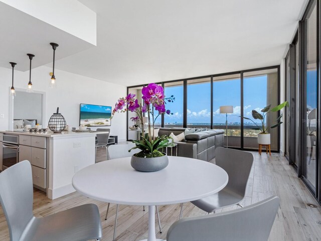 dining space with light wood-type flooring and floor to ceiling windows