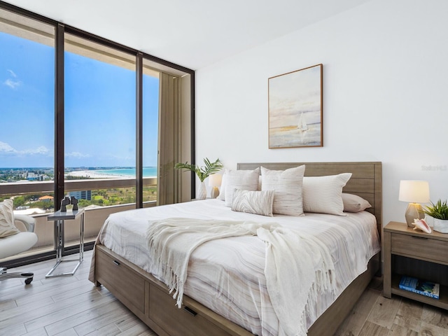 bedroom featuring expansive windows and a water view