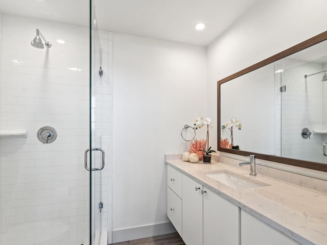 bathroom featuring vanity, a shower with shower door, and hardwood / wood-style flooring