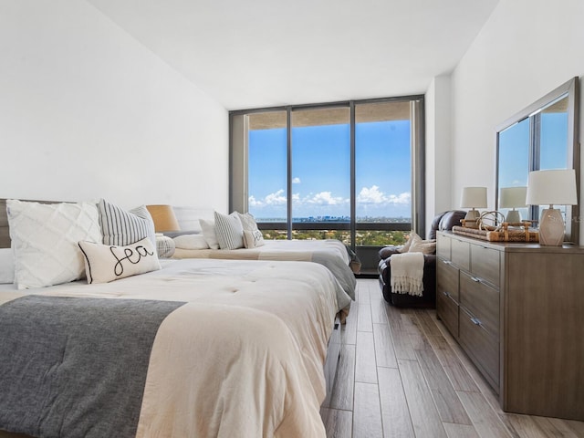 bedroom featuring light hardwood / wood-style flooring and expansive windows