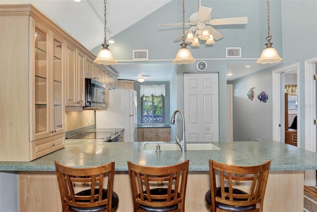 kitchen featuring ceiling fan, kitchen peninsula, pendant lighting, backsplash, and a kitchen bar