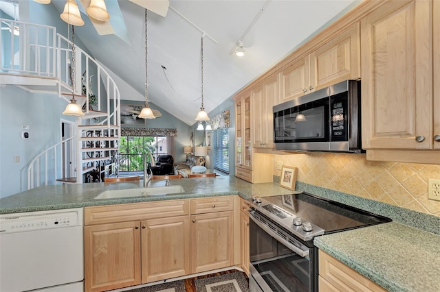 kitchen featuring appliances with stainless steel finishes, vaulted ceiling, sink, track lighting, and light brown cabinetry