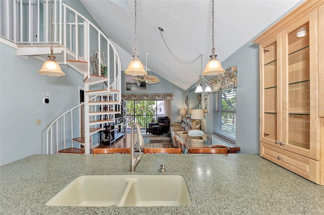 kitchen featuring high vaulted ceiling, sink, light brown cabinetry, and pendant lighting