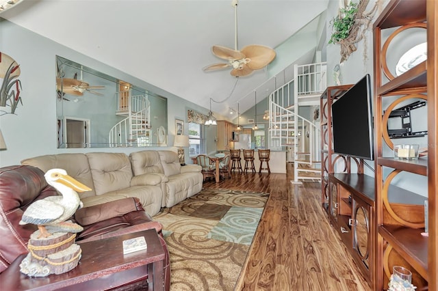 living room with ceiling fan, vaulted ceiling, and wood-type flooring