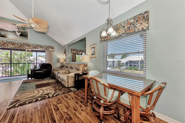 dining space with hardwood / wood-style floors, ceiling fan with notable chandelier, and lofted ceiling