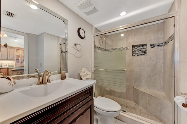 bathroom with a shower with shower door, vanity with extensive cabinet space, tile flooring, and toilet