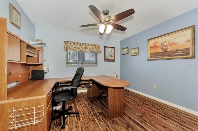 office space with built in desk, dark hardwood / wood-style flooring, and ceiling fan