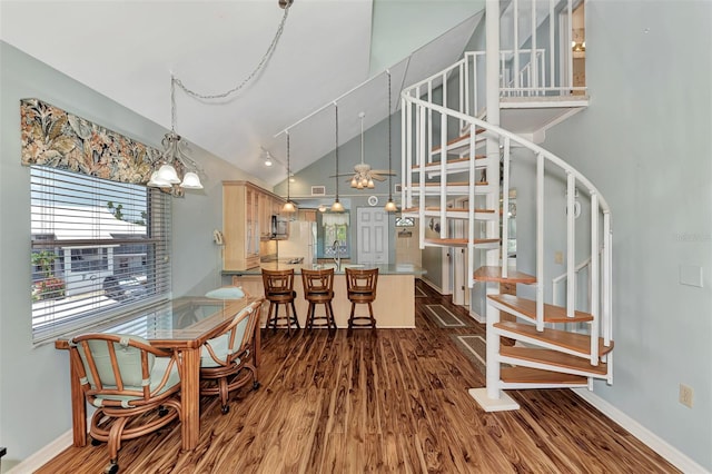 dining room featuring high vaulted ceiling, an inviting chandelier, hardwood / wood-style flooring, and track lighting