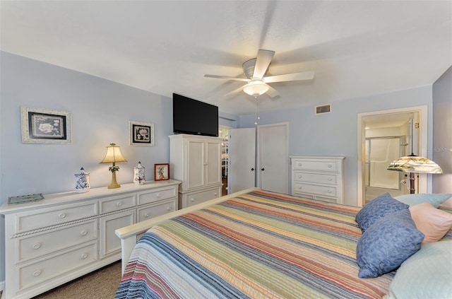 carpeted bedroom with ensuite bathroom and ceiling fan