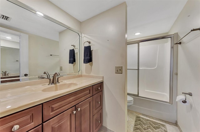 full bathroom with tile floors, enclosed tub / shower combo, toilet, and vanity